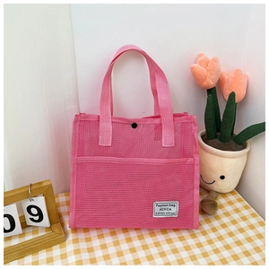 Detailed view of pink mesh tote bag featuring an outer pocket and secure snap button