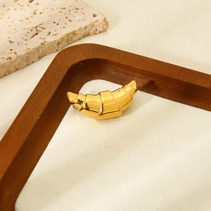 Detailed close-up of 18k gold plated ribbed croissant brooch on elegant fabric display