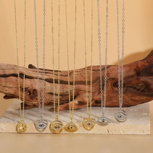 Detailed shot of evil eye and smiley necklaces in gold and silver with blue zircons
