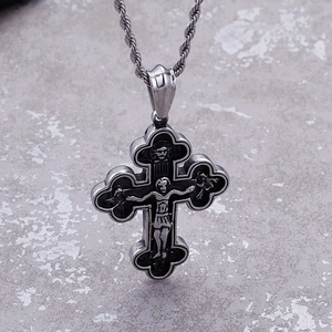 Macro shot of silver vintage cross pendant with Jesus relief and stainless steel twist chain