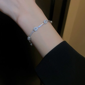 Détail d'un bracelet en argent serti de zircons ovales sur un poignet féminin