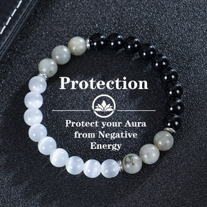 Detail of triple beaded protection bracelet with tiger eye on black leather background