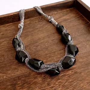 Multi-strand metal chain necklace with large faceted black acrylic oval pendants