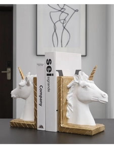 Détail macro d'un serre-livres licorne blanc avec corne dorée et texture de grain de bois