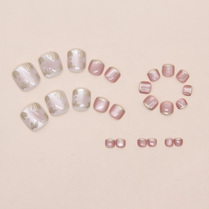 Macro detail of pink pearl press-on toenails with gold floral relief and French tips