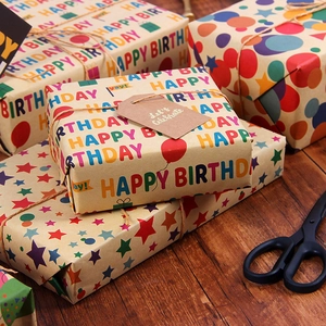 Birthday kraft gift wrapping paper set with colorful Happy Birthday prints on wooden table