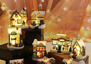 Detailed view of LED lighted Christmas resin houses with snowy roofs and warm star lights