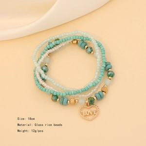 Detail showing mint green and white seed bead bracelet set with heart love charm