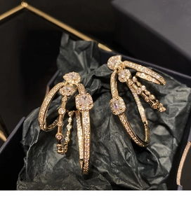 Detailed close-up of gold layered oval hoop earrings with sparkling cubic zirconia inlay