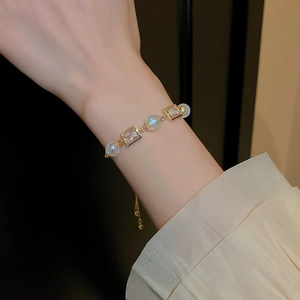 Detailed shot of an adjustable gold bracelet with square cubic zirconia and pearls