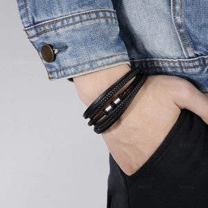 Men's multilayer braided black leather bracelet with silver metal clasp on male wrist