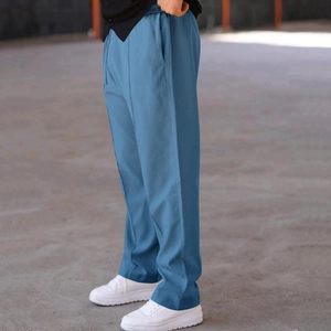 Side view of men's loose fog blue trousers showing smooth drape and casual fit
