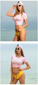 Dettaglio del crop top rosa e pantaloncini di jeans gialli con frange sulla spiaggia