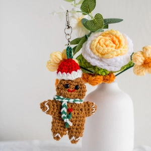 Handmade crochet gingerbread man keychain with festive hat and heart on a neutral background
