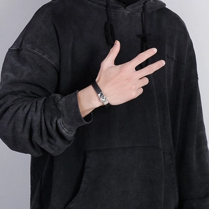 Close-up of black braided leather bracelet with silver buckle on male model wrist