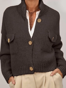 Detailed texture of dark grey knit cardigan featuring distinctive wooden buttons and pockets