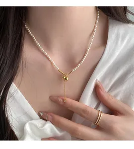 Gros plan du collier en perles cœur or 18 carats avec pendentif diamant sur un mannequin