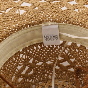Detail shot of a 100% paper straw cowboy hat showing internal sweatband and labels