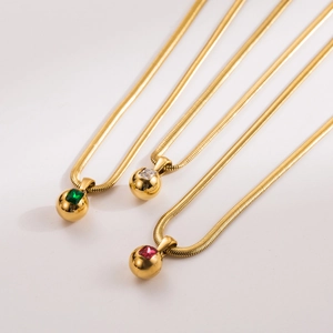 Three gold snake chain necklaces with colorful square gemstone sphere pendants on cream base