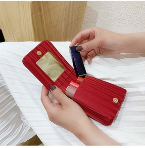 Detail of red mini lipstick pouch with built-in mirror and three storage slots