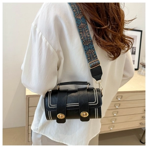 Detail of black Boston bag with beaded trim and decorative woven wide shoulder strap