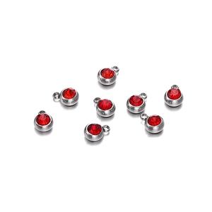 Détail de huit pendentifs en acier argenté avec pierres de naissance en zircon rouge