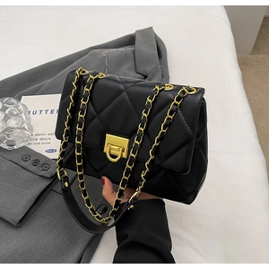 Detailed view of black quilted PU leather crossbody bag with gold-tone twist lock and chain strap