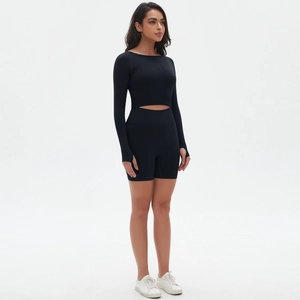 Detail eines schwarzen bauchfreien Langarmshirts mit Daumenlöchern und Yoga-Shorts