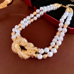 Vintage double layer pearl necklace with large textured gold knot buckle over silk