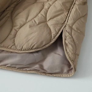 Detailed wave quilting and ripstop pattern on khaki cotton jacket with purple lining