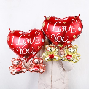 Detail of red heart-shaped foil balloons with I Love You print and cute bear characters