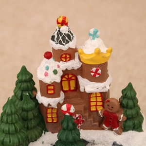 Close-up of resin gingerbread man and house Christmas musical spinning train decoration