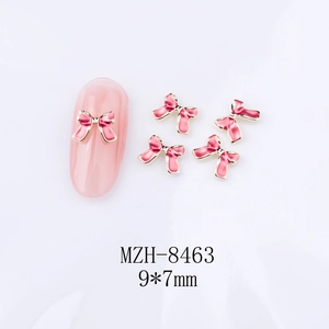 Vue détaillée des bijoux d'ongles nœuds roses 9x7mm avec base en métal doré pour manucure