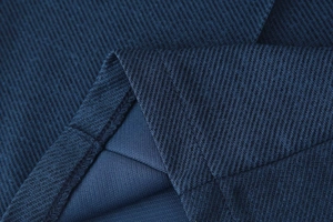 Détail de la texture du tissu sergé bleu marine avec des coutures professionnelles