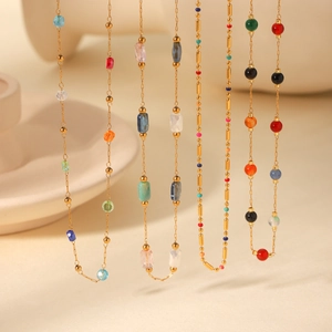 Detailed macro view of colorful natural stone beads on a golden stainless steel necklace