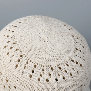 Close-up of cream hollow knit bucket hat showing intricate breathable weave patterns
