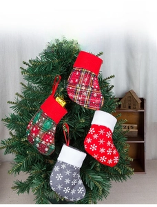Close-up of four plaid and snowflake knit Christmas stockings hanging on a festive tree