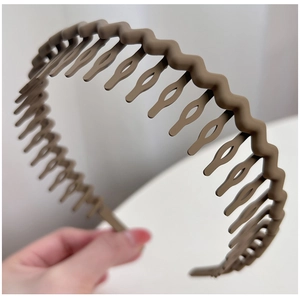 Detail view of wavy non-slip brown headband featuring fine teeth for secure hair styling