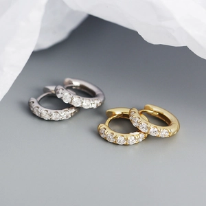 Détail de créoles en or et argent avec pavé de zircons blancs et finition polie
