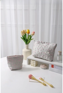 Detailed close-up of floral embossed vanity bag set with tulip patterns and metal zippers