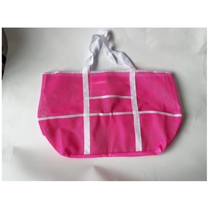 Pink mesh beach bag detail with white handles and multiple exterior storage pockets