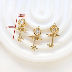 Detail of 18k gold plated key pendant with cubic zirconia and angel wings motif