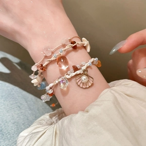 Close-up of bohemian beaded bracelet featuring natural shell charms and starfish pendants