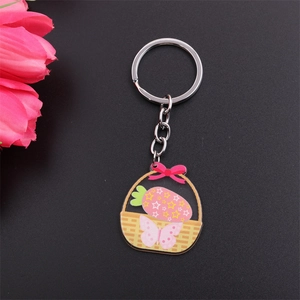 Detail of cartoon Easter basket keychain with pink stars and strawberry on dark background