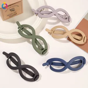 Macro detail of infinity shaped matte frosted hair claw clips in assorted pastel colors