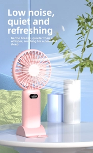 Close-up detail of a pink portable mini fan with digital display in a cozy indoor scene
