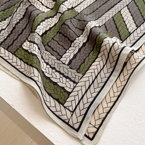 Close-up of woven chain pattern texture on elegant silk scarf with natural folds