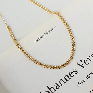 Macro shot of gold wheat ear pattern necklace with 18K plating on stainless steel