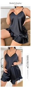 Detail eines schwarzen Satin-Camisole-Sets mit V-Ausschnitt und Rüschen-Schlafshorts