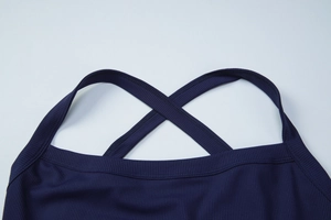 Detail view of navy blue knitted fabric showing cross-back straps and ribbed texture